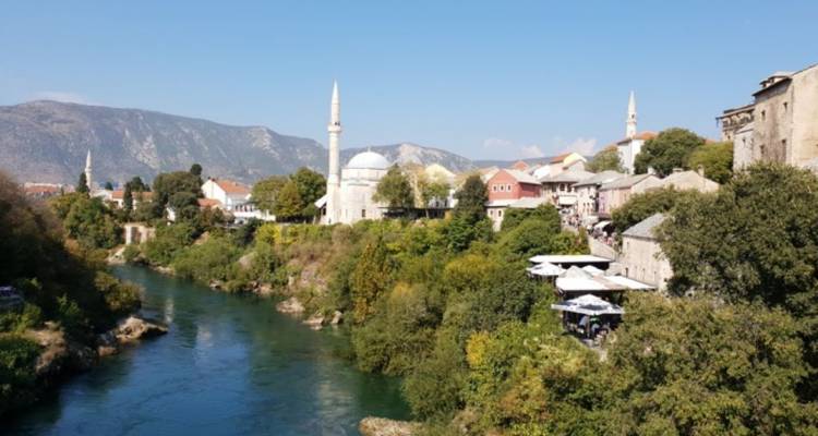 Vista ribereña de una ciudad con una mezquita y montañas.
