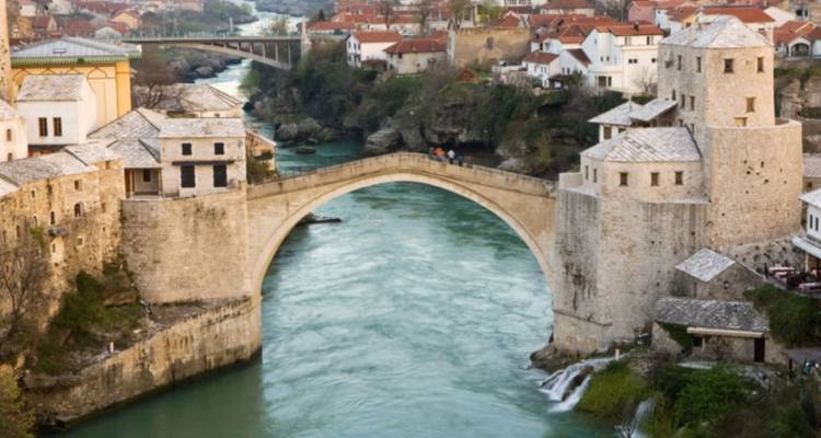 Puente histórico de piedra arqueado sobre un río.