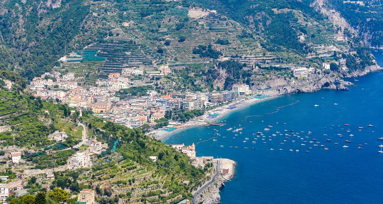 Aerial view of a coastal town with terraced greenery and beaches.