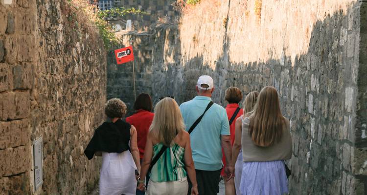 Groupe de touristes marchant le long d'un étroit sentier de pierre.