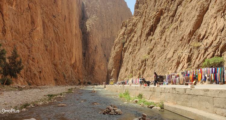 Une gorge avec une rivière et des tissus colorés exposés sur le côté.