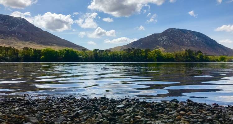 Vista escénica del lago con montañas al fondo y cielos despejados.