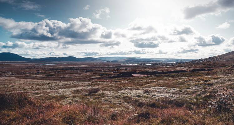 Vista expansiva de un paisaje agreste con nubes en el cielo.