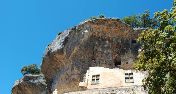 Historisches Gebäude, das in Felsformationen hineingebaut wurde.