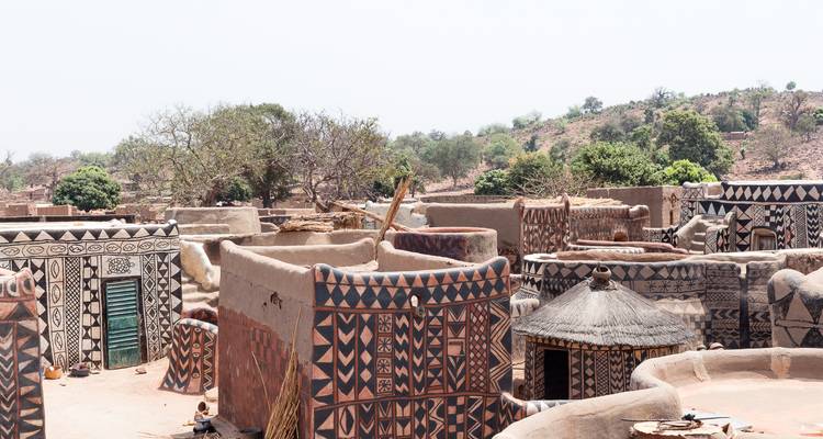 Village traditionnel avec des maisons en terre cuite ornées de peintures décoratives.