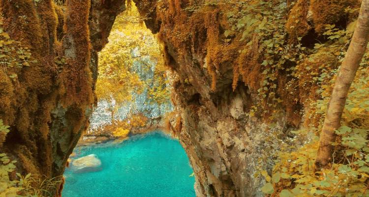 Natural arch formation with clear blue water.