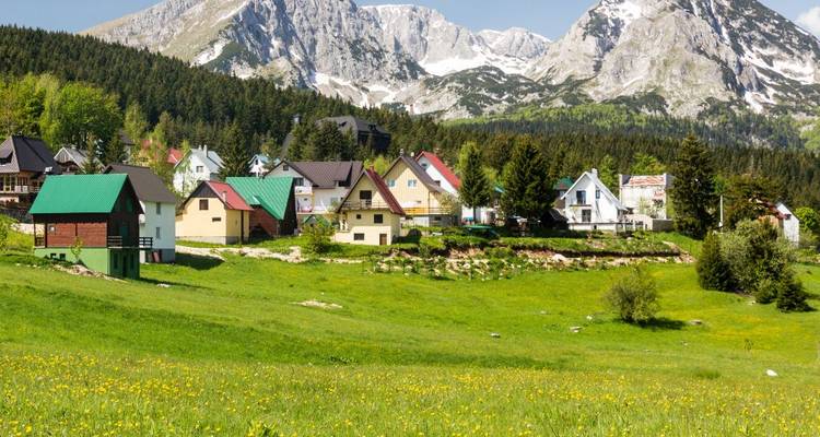 Charming village with mountains and green fields.