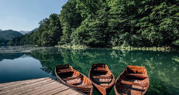 Tranquil lake surrounded by forested hills.