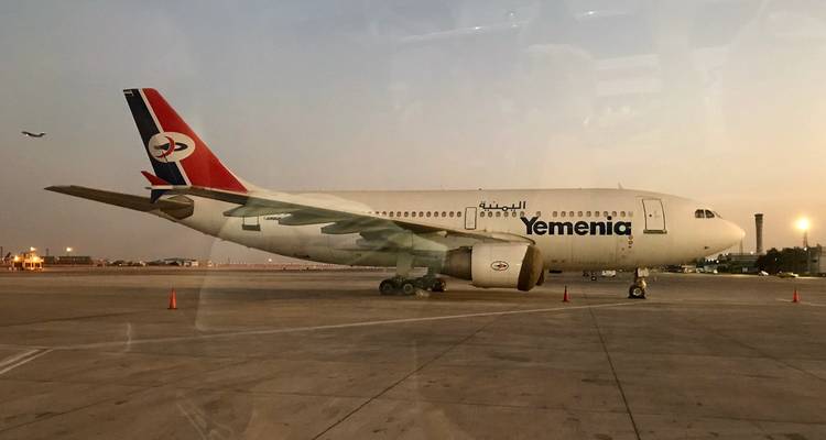 Avion Yemenia garé sur un tarmac au crépuscule.