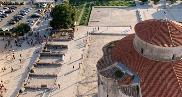 Luchtfoto van een historisch gebied met een ronde kerk en open ruimte.