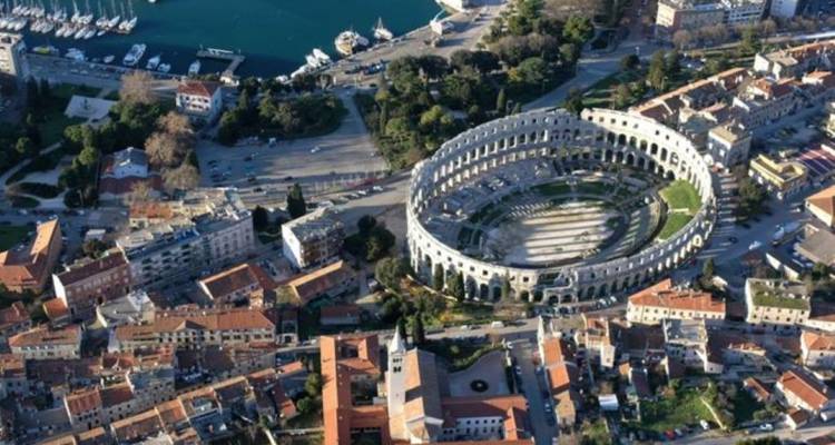 Vue aérienne d'un amphithéâtre romain dans une ville.