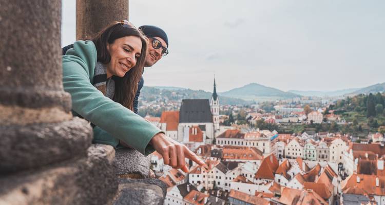 Pareja observando un pueblo desde un punto de vista elevado.