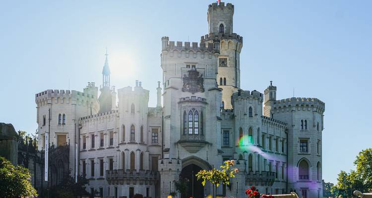Castillo con luz solar y jardines exuberantes.