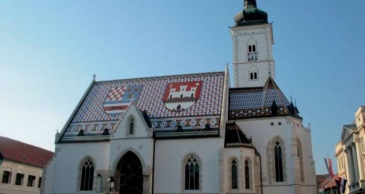 Église historique avec un toit de tuiles colorées.