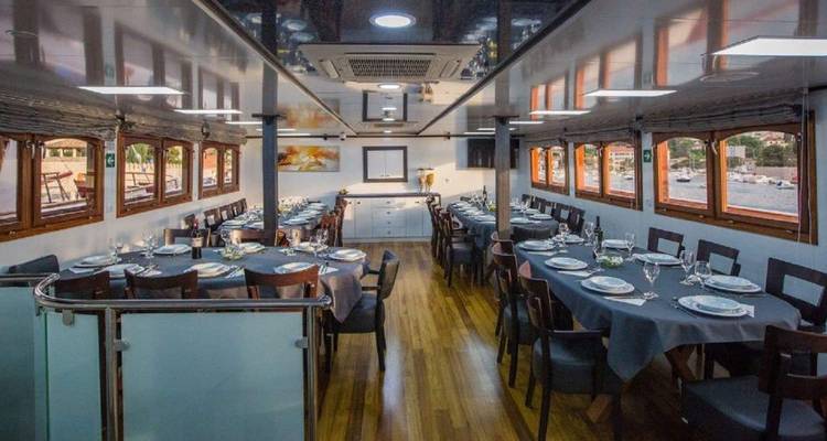 A well-set dining area on a boat with views of the water.