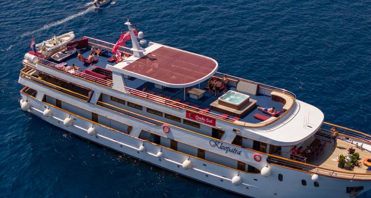 Aerial view of a cruise ship with a jacuzzi, people, and surrounding waters.