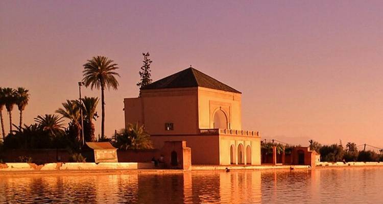 Pavillon au bord d'un lac sous un ciel de coucher de soleil.