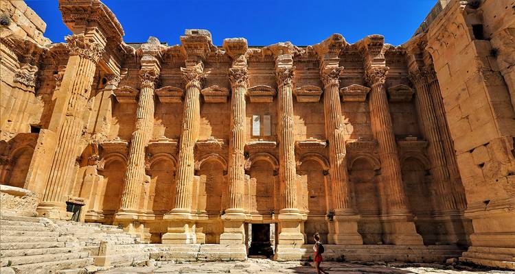 Grande structure avec des piliers anciens et une personne en visite.