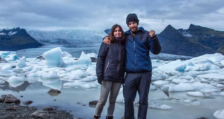 Twee mensen voor een gletsjer en ijsbergen.