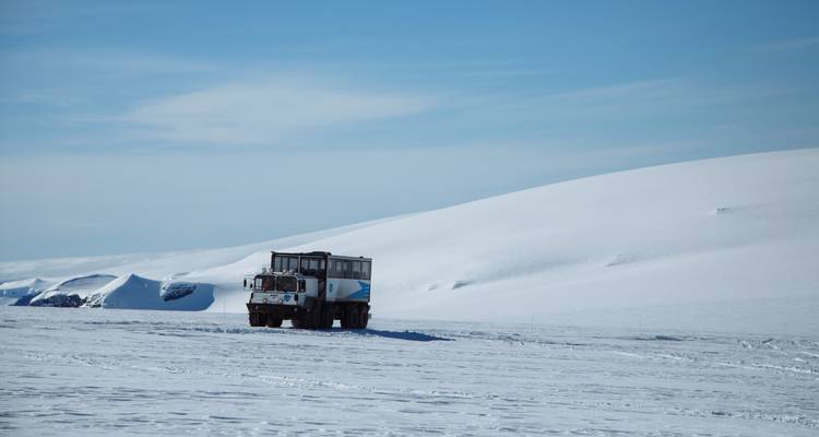Vrachtwagen op een besneeuwd landschap met een uitgestrekte lucht.