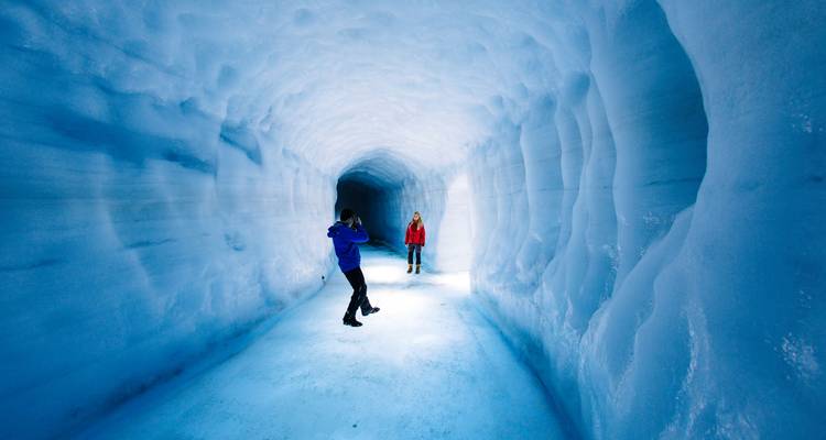 Twee mensen in een ijsgrot, één maakt een foto.