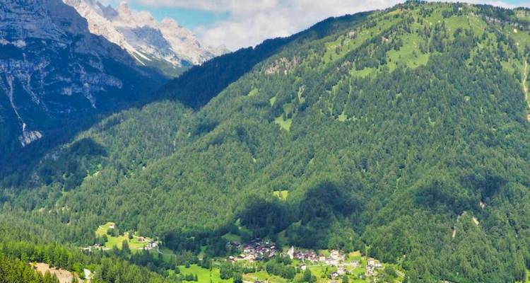 Un pueblo enclavado entre verdes colinas y montañas.