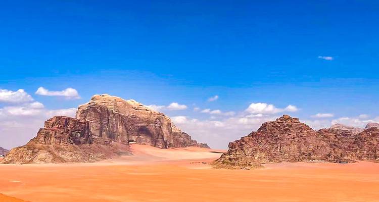 Vast desert landscape with unique rock formations under a blue sky.