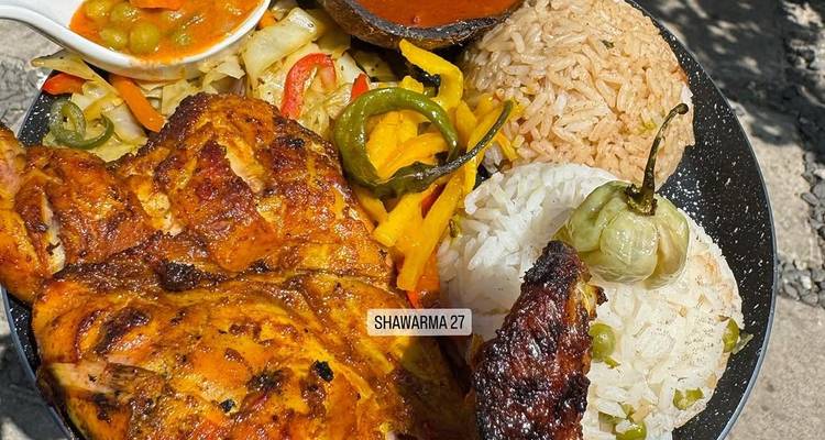 Poulet grillé et riz avec divers accompagnements servis dans une assiette.