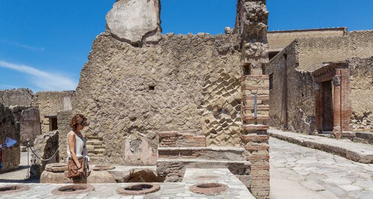 Tourists examining ancient ruins and structures.