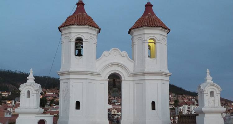 Vieja iglesia blanca con torres gemelas contra un cielo azul.