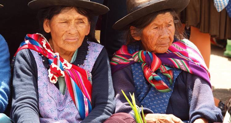 Mujeres ancianas en ropa tradicional sentadas al aire libre.