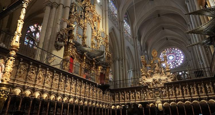 Intérieur complexe d'une cathédrale avec des sculptures ornées et de hauts plafonds.