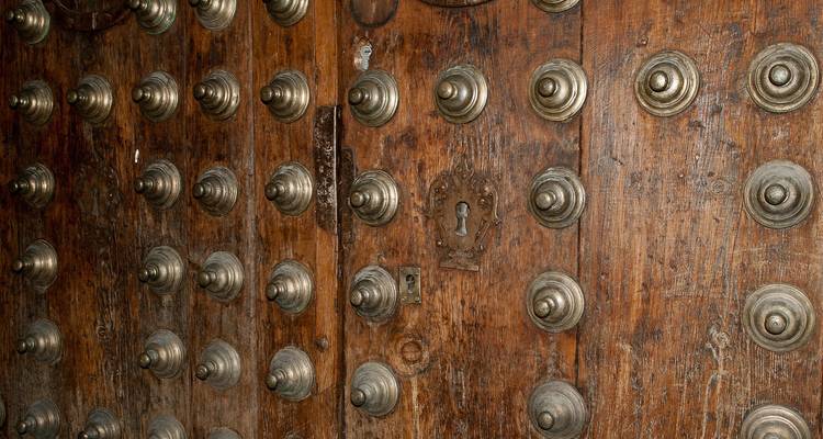 Vue en gros plan d'une porte en bois traditionnelle avec des clous métalliques.