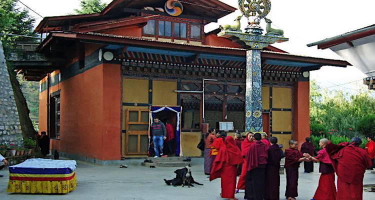 Groupe de moines en robes rouges rassemblés autour d'un temple