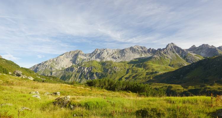 Weitblick auf eine Alpenlandschaft mit üppigem Grün.