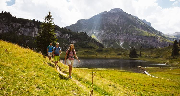 Wanderer genießen einen malerischen Spaziergang in der Nähe eines Bergsees.