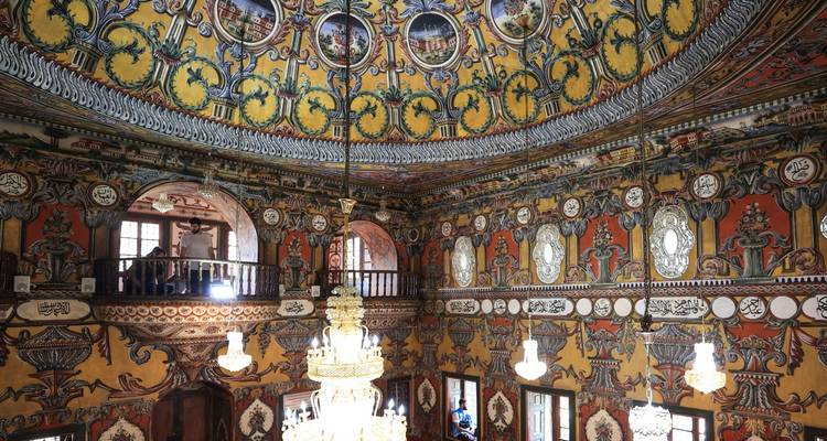 Plafonds voûtés richement décorés à l'intérieur d'un bâtiment historique.