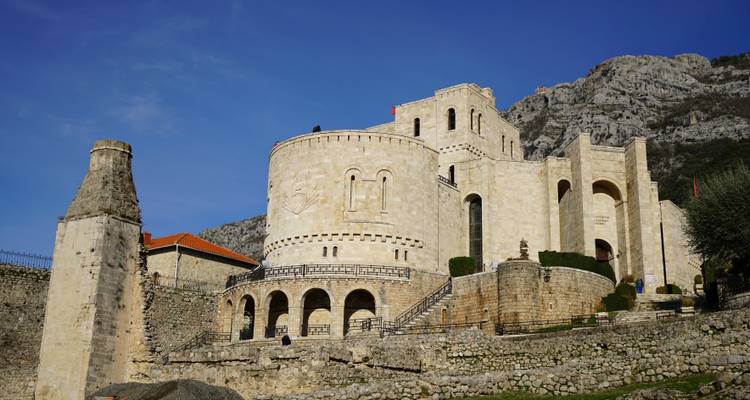 Une grande forteresse historique nichée près d'une chaîne de montagnes.