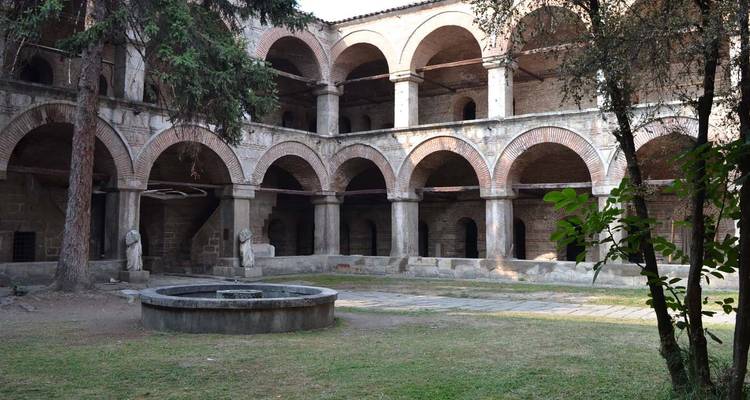 Une cour historique avec plusieurs arcs en pierre.