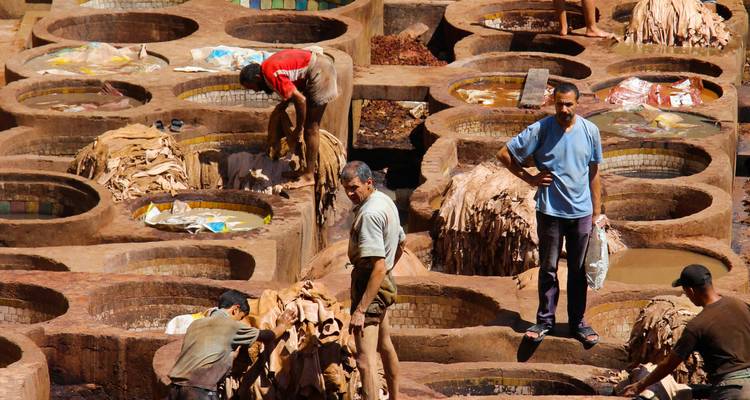 People working with leather in traditional tannery vats.