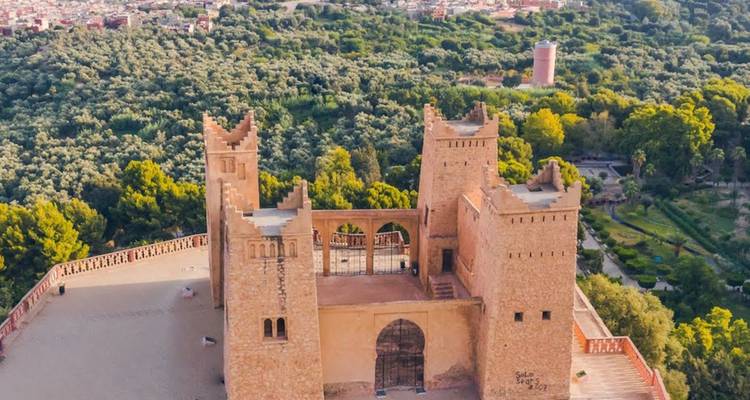 Vue aérienne de la Kasbah Ras el Ain surplombant la forêt luxuriante et la ville de Béni Mellal.