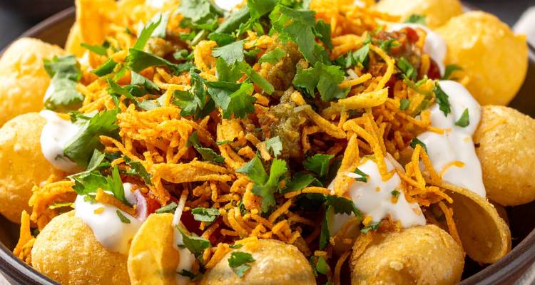 Un plat de papri chaat garni de coriandre et de chutney.