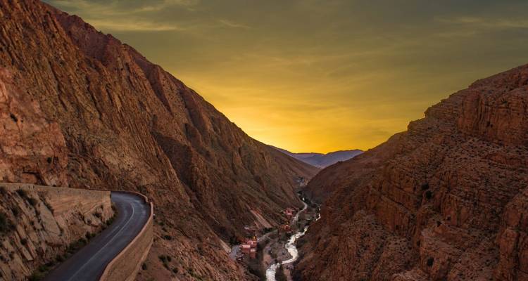 Sonnenuntergang in einer Schlucht mit einem sich hindurchschlängelnden Fluss.