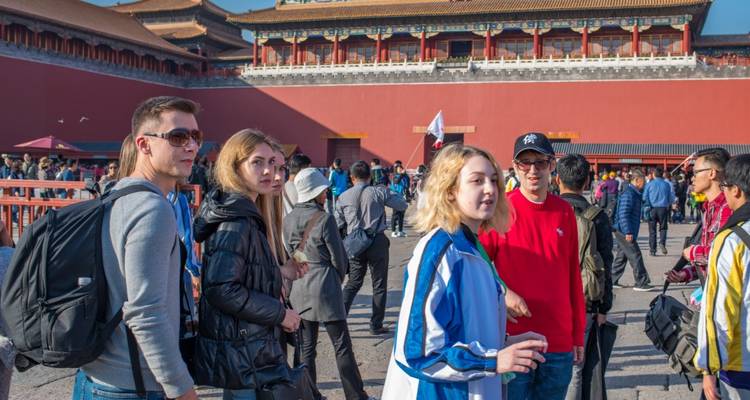 Touristen in historischem Innenhof mit traditionellen Gebäuden.