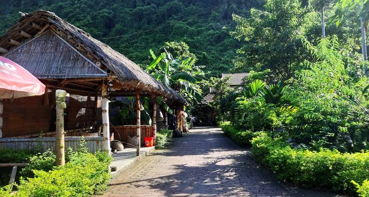 Sendero junto a edificios tradicionales con techo de paja.