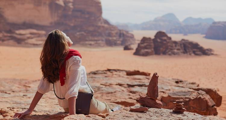 Personne se relaxant sur un rocher dans un paysage désertique