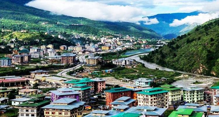 Luchtfoto van een kleurrijke stad aan een rivier in een bergachtige streek.