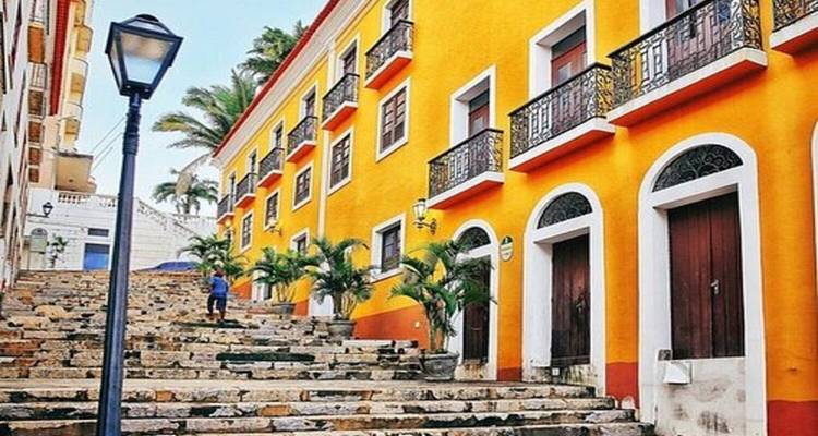 Kleurrijke trappen met koloniale gebouwen en palmbomen.