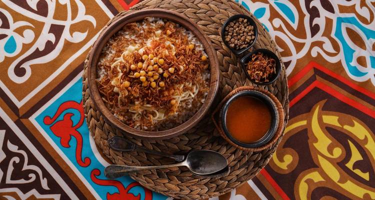 Traditioneel Egyptisch gerecht Koshari geserveerd op een kleurrijke mat.