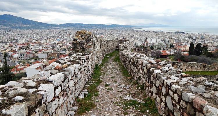 Étroit chemin de ronde crénelé serpente le long des murs du château au-dessus de la ville portuaire tentaculaire.